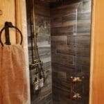 Hébergement Douche avec porte en verre et patère portant une serviette au premier plan