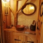 Hébergement Salle de bain artisanale en bois avec vasque en cuivre, miroir et luminaire