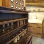 Hébergement Vaisselier ancien présentant des verres en étain et des ustensiles en grès, cuisine floue en arrière-plan
