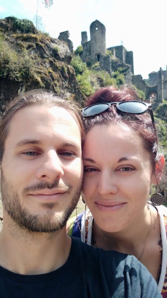 Photo de deux personnes en vacances au pied d’un château