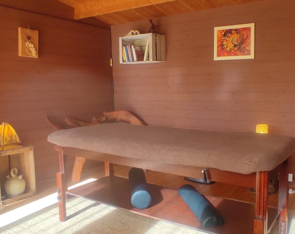 Intérieur du chalet de massage avec ambiance cosy et décor naturel au Coteau des Fadets